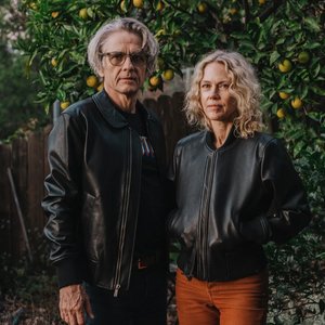 Two people standing on a path surrounded by greenery in CLADE leather jackets