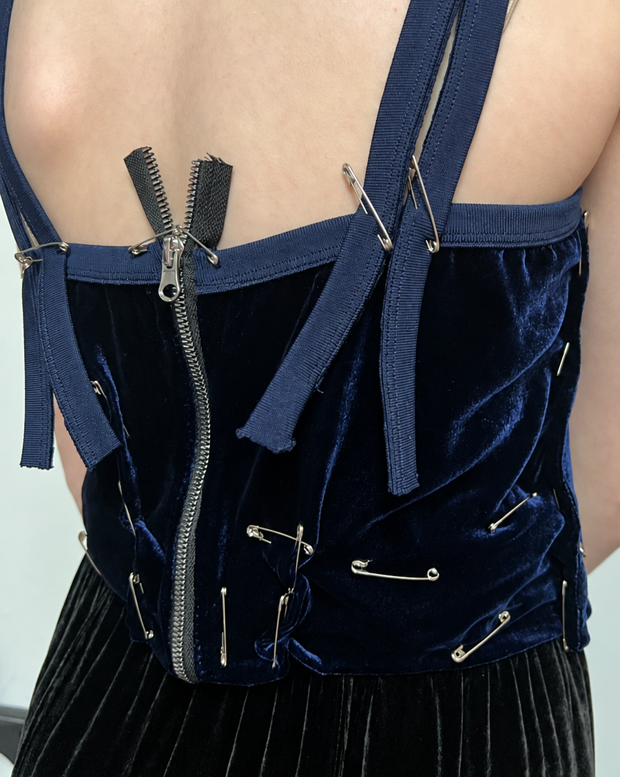 Close up of a fitting where pins indicate where straps should be attached and where excess fabric should be removed. 